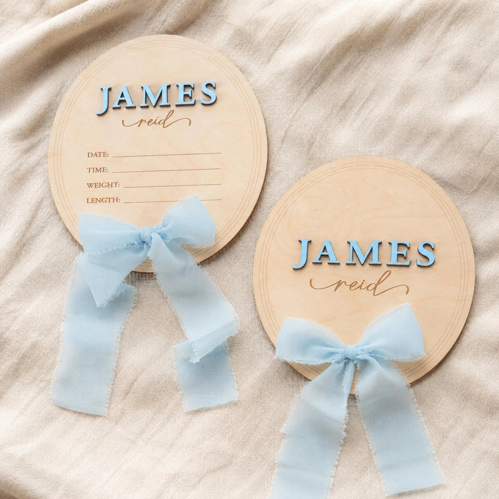 Oval baby name plaque and birth announcement sign with light blue ribbon, name James Reid